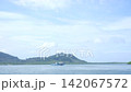 Distant Passenger Ferry Boat Sailing Across Ocean Channel with Tropical Mountain View in Krabi 142067572