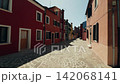 Burano street bordered by colorful houses and sunlight Burano street bordered by colorful houses and sunlight 142068141