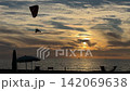 Powered Paraglider Flying Over Sea Sunset 142069638