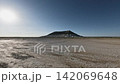 Off-road vehicle speeds across rugged terrain under bright sunlit sky 142069648