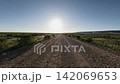 Off-road driving on gravel road under bright sun in open landscape 142069653