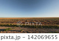Off-road driving on rugged terrain with expansive grassland landscape visible 142069655