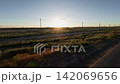 Off-road driving through rugged terrain at sunset with visible power lines 142069656