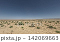 Off-road vehicle speeds across arid landscape with sparse vegetation and hills 142069663