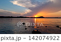Continuous 4K wide angle time lapse of the partial solar eclipse sunset 2026 in Spain. Crescent sun dipping behind Denia castle with dramatic dual color sky split between orange horizon and blue dusk 142074922