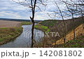 Horizontal slow panning panoramic shot of the Don River horseshoe bend with steep bank, agricultural plowed fields, and spring forest under a cloudy sky near Krivoborye village, Voronezh region, Russi 142081802