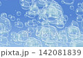 Soap bubbles float upwards against a blue background and pop. Bubbles underwater. 142081839