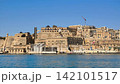 Historic Valletta waterfront with Saluting Battery and Upper Barrakka Gardens, visible cannon smoke above bastions, bright blue sky and harbor setting in Malta 142101517