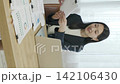 A young Japanese businesswoman working on her computer by a bright window (vertical video) 142106430