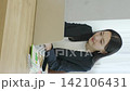 A young Japanese businesswoman working on her computer by a bright window (vertical video) 142106431