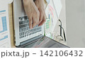 A close-up of a Japanese businesswoman's hands working on a computer by a bright window (vertical video). 142106432