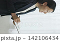 A young Japanese businesswoman smiles as she takes notes in a binder by the window (vertical video). 142106434