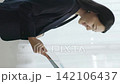 A young Japanese businesswoman smiles by a window, holding a file (vertical video). 142106437