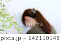 A person who is depressed and troubled, with their head pressed against a binder. 142110145