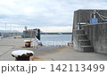 A quiet harbor under a cloudy sky and the gently rippling surface of the water. 142113499