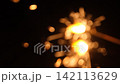 The blurred light of handheld fireworks bursts and fades away on a summer night. 142113629