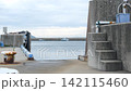 The water surface and concrete quay gently sway in the quiet harbor. 142115460