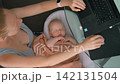 Remote work at home with baby sleeping in soft baby nest. 142131504