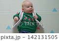 Three month old baby in christmas outfit looking at camera. Close-up. Slow motion. 142131505