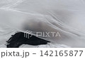Body beauty and fashion advertisement. Female in underwear laying on the bed in the studio. Young woman seminude in lingerie laying posing under thin sheet of oilcloth wrap, full shot. 142165877