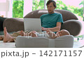 Working father on sofa as baby starts fussing in cocoon. Slow motion. 142171157