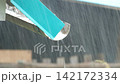 A vertical video showing rainwater flowing and dripping from a gutter during a heavy downpour. Continuous streams and drops of rainwater flow and fall over the edge 142172334