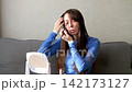 A video showing the lifestyle of a young woman with braces and long dark hair, sitting at a table in front of a mirror, applying eyeshadow. She's applying eye makeup as part of her personal at-home be 142173127