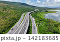 Aerial view of highway running along river and green hills. Transportation, infrastructure, travel and logistics concept 142183685