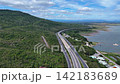 Aerial view of highway running along river and green hills. Transportation, infrastructure, travel and logistics concept 142183689