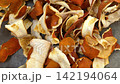 Dried orange peels scattered on gray concrete surface, closeup texture. Citrus zest, natural drying, homemade spice, food waste, eco storage. 142194064