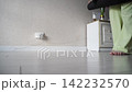 Static Shot Of Woman Unrolling Yoga Mat And Preparing Indoor Exercise Space In Home Room  142232570