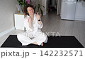 Static Shot Of Woman Sitting On Yoga Mat Performing Facial Massage And Playful Expressions  142232571