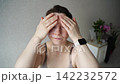 Static Shot Of Woman Massaging Face While Applying Skincare Mask During Relaxed Self Care Routine 142232572