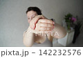 Static Shot Of Woman Stretching Arms And Wrists During Morning Wellness Routine In Home Interior 142232576