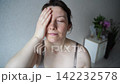Static Closeup Portrait Of Woman Applying Face Cream And Massaging Cheek During Skincare Routine  142232578