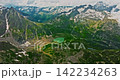 Establishing shot of Switzerland. Aerial view of the green meadows of Switzerland, with the Alps and clouds in the background 142234263