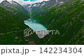 Establishing shot of Switzerland. Aerial view of the green meadows of Switzerland, with the Alps and clouds in the background 142234304