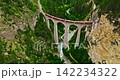 Aerial video of the red train traversing the Landwasser viaduct. The Swiss Express travels through the green meadows and mountains of Switzerland. Passenger transportation in Switzerland 142234322