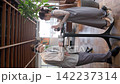 一對年輕的商務人士，一男一女，在咖啡館的站立式桌子旁開會。 142237314