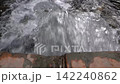 Small waterfall flowing over rocks in natural setting 142240862