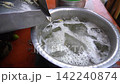 Refreshing Sugarcane juice Preparation with Ice and Herbs in a Metal Bowl 142240874