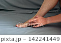 Person applying medicinal cream to a small skin injury on their ankle 142241449