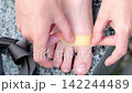 A child's hands carefully apply a bandage to a wound on his leg. The footage shows a simple first aid procedure and treatment for a minor leg injury. 142244489