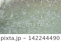 Close-up video of heavy rain falling onto a puddle, creating countless splashes, ripples, and water droplets across the surface. Atmospheric footage of intense rainfall and wet weather 142244490
