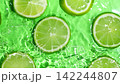 Top view of fresh green lime slices floating in clear rippling water slow motion 142244807