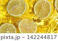 Top view slow motion of juicy halved lemon slices floating in clear water with ripples 142244817