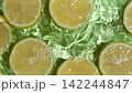 Top view slow motion of juicy halved lemon slices floating in clear water with ripples 142244847