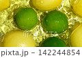 Whole lemons and limes splashing in clear water from above in slow motion 142244854