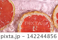 Slow motion of fresh grapefruit slices under rippling water with bubbles 142244856