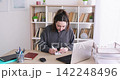 Employee routine. Business notes. Woman manager working at desk writing task on sticky paper beside laptop at professional workplace. 142248496